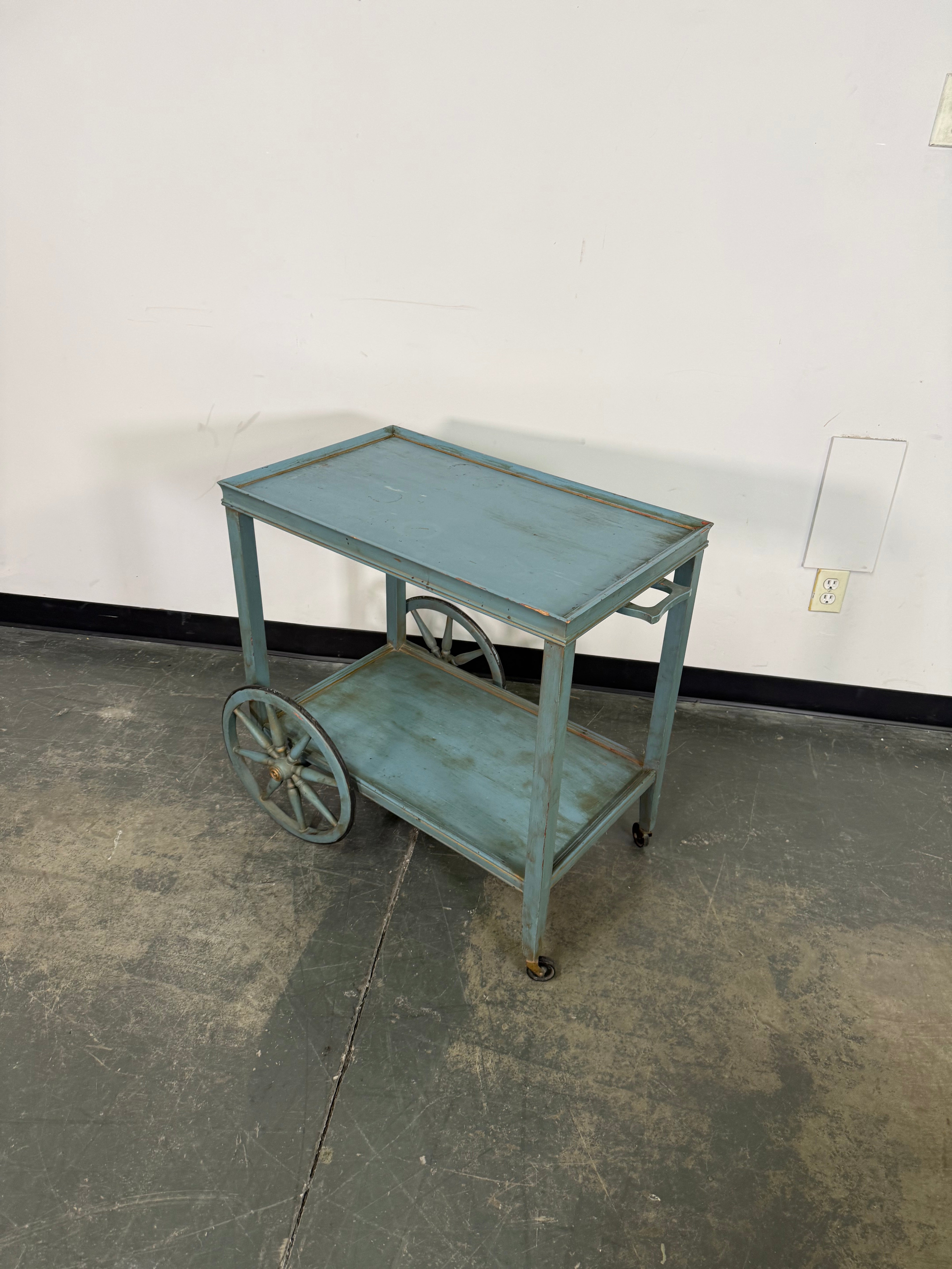 Small metal cart against a wall with a concrete floor
