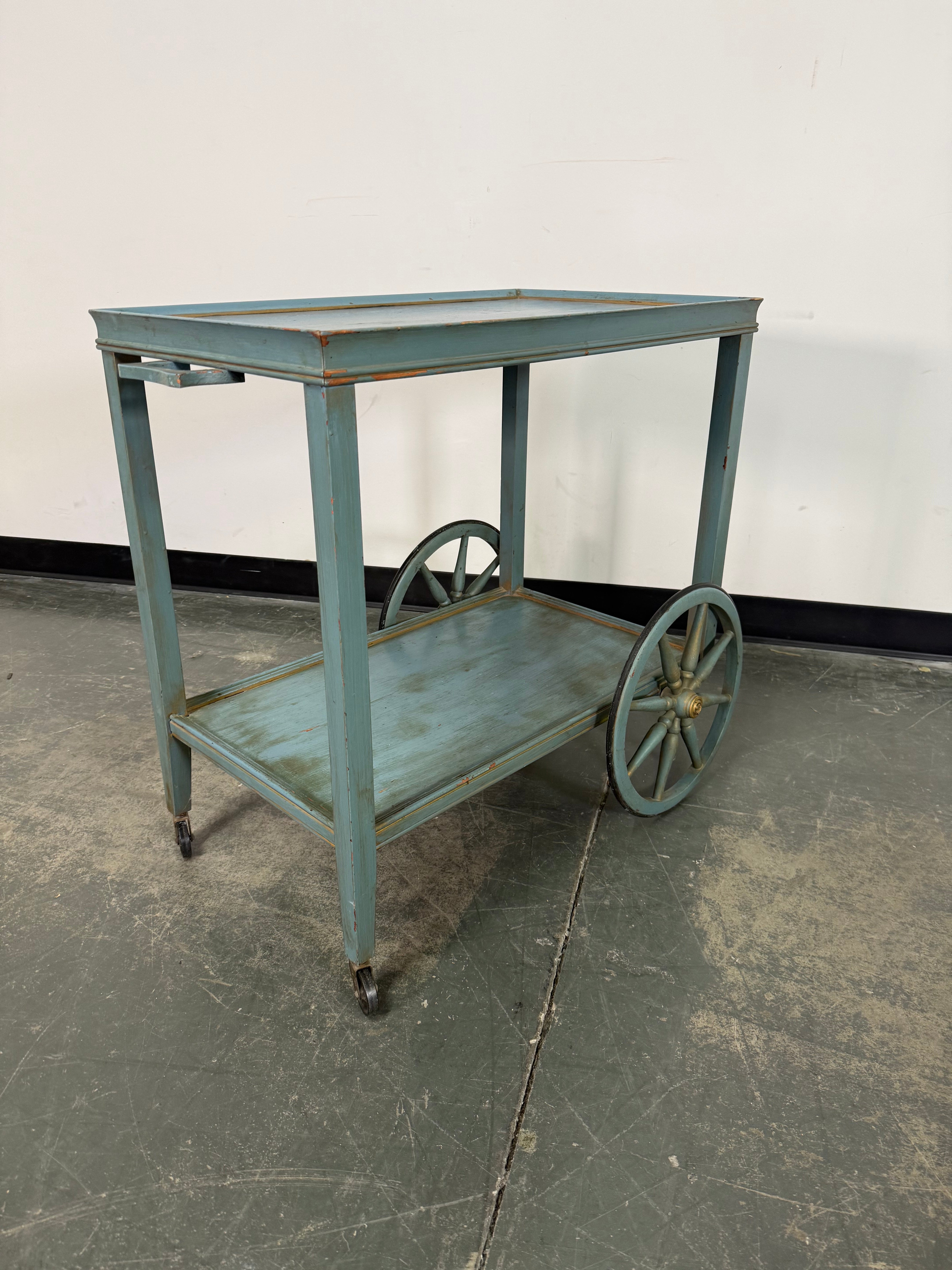 Small metal cart against a wall with a concrete floor