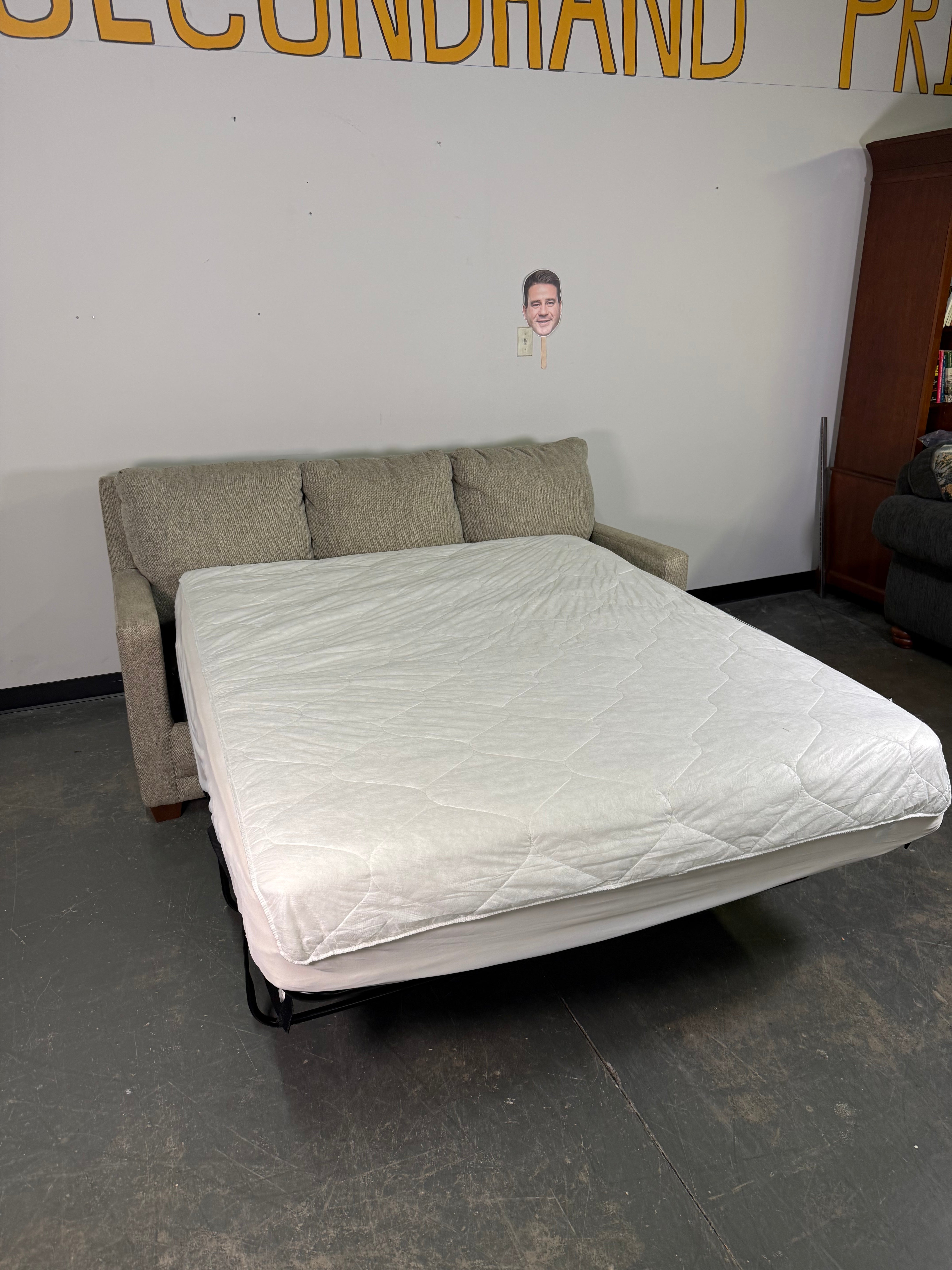Beige sofa against a white wall with a dark floor.